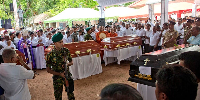 A soldier stands guard during a funeral service attended by Cardinal Malcolm Ranjith for Easter Sunday bomb blast victims at St. Sebastian Church in Negombo, Sri Lanka, on Tuesday. (AP)