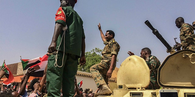 Sudanese forces celebrate on Thursday after officials said the military had forced longtime autocratic President Omar al-Bashir to step down after 30 years in power.