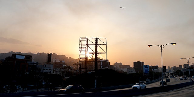 A billboard stands empty above a highway with no traffic as the sun sets in Caracas, Venezuela, Monday, March 18, 2019. When the sun goes down in Venezuela's capital, the once-thriving metropolis empties under darkness. (AP Photo/Natacha Pisarenko)