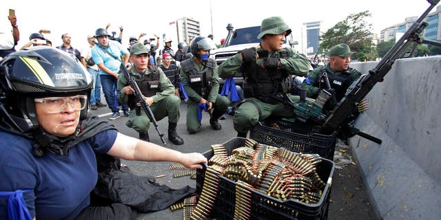 An anti-government protester sits by ammunition being used by rebel troops rising up against the government of Venezuela's President Nicolas Maduro as they all take cover on an overpass outside La Carlota military airbase where the rebel soldiers confront loyal troops inside the base in Caracas, Venezuela.