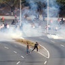 People react to tear gas near the Generalisimo Francisco de Miranda Airbase in Caracas, April 30, 2019. 