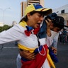 A woman suffocated by tear gas is helped by fellow opponents of President Nicolas Maduro outside La Carlota air base in Caracas, April 30, 2019. 