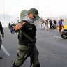 An uprising member of the Bolivarian National Guard gestures outside La Carlota air base in Caracas, Tuesday, April 30, 2019. 