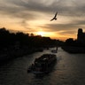 Boats sail along the Seine river next to the Notre Dame Cathedral as the sun sets in Paris, April 21, 2019. 