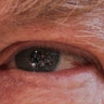 Members of the media are seen reflected in the eye of President Donald Trump as he answers questions on the South Lawn of the White House in Washington, April 10, 2019. 