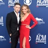Michael Ray, in a black suit, and Carly Pearce, in a vibrant red gown with a plunging neckline, make it a date night at the 2019 ACM Awards.