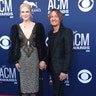 Nicole Kidman, in a shimmery number, and Keith Urban, in an animal print suit, hold hands at the 54th annual Academy of Country Music Awards.