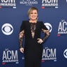 Kelly Clarkson is all smiles in a black gown with lace detailing.