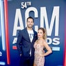 Eric Decker, in a blue suit, and Jessie James Decker, in a mini dress with heart detailing, keep close at the award show.