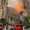 Flames and smoke are seen billowing from the roof at Notre Dame Cathedral.