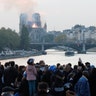 People watch as smoke billows from Notre Dame Cathedral.