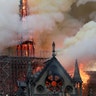 Smoke billows as the fire engulfs the spire of Notre Dame Cathedral in Paris.