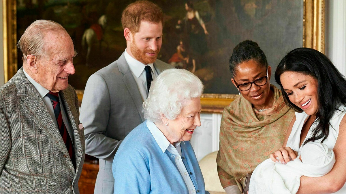 In this image made available by SussexRoyal on Wednesday, May 8, 2019, Britain's Prince Harry and Meghan, Duchess of Sussex, joined by her mother Doria Ragland, show their new son to Queen Elizabeth II and Prince Philip at Windsor Castle, Windsor, England.