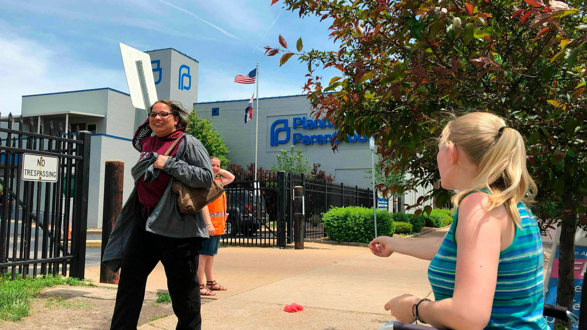 Anti-abortion activist Teresa Pettis, right, greets a passerby outside the Planned Parenthood clinic in St. Louis. last month. (AP Photo/Jim Salter, File)