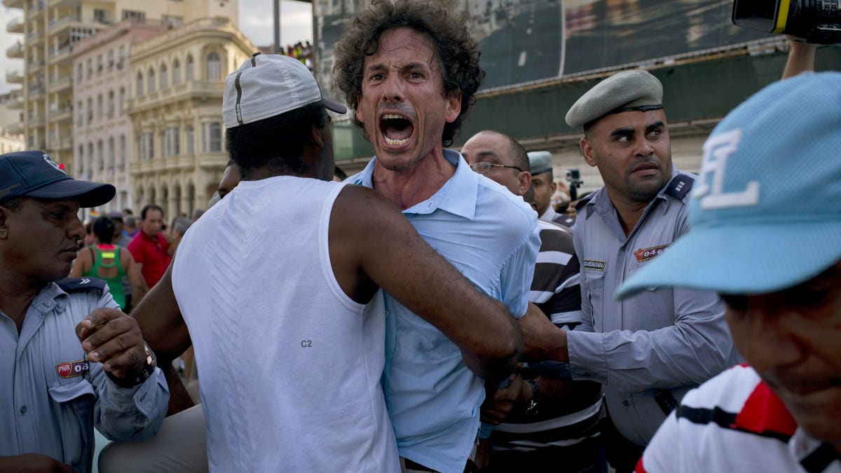 Cuban police detain a gay rights activist taking part in an unauthorized march in Havana, Cuba, Saturday, May 11, 2019. The march was organized largely using Cuba's new mobile internet, with gay-rights activists and groups of friends calling for a march over Facebook and WhatsApp after the government-run gay rights organization canceled a Saturday march.