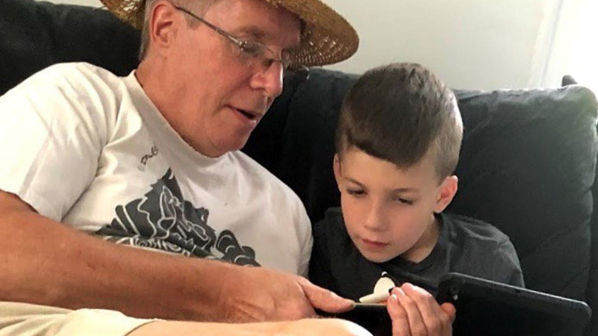 This summer 2018 photo provided by Al Mattin on Friday, May 10, 2019 shows his father, Stephen, and son, Ronan, at Stephen's home in Kensington, N.H. The Handel & Haydn Society had just finished a rendition of Mozart's "Masonic Funeral" at Boston's Symphony Hall on Sunday, May 5, 2019 when a youngster blurted out: "WOW!"