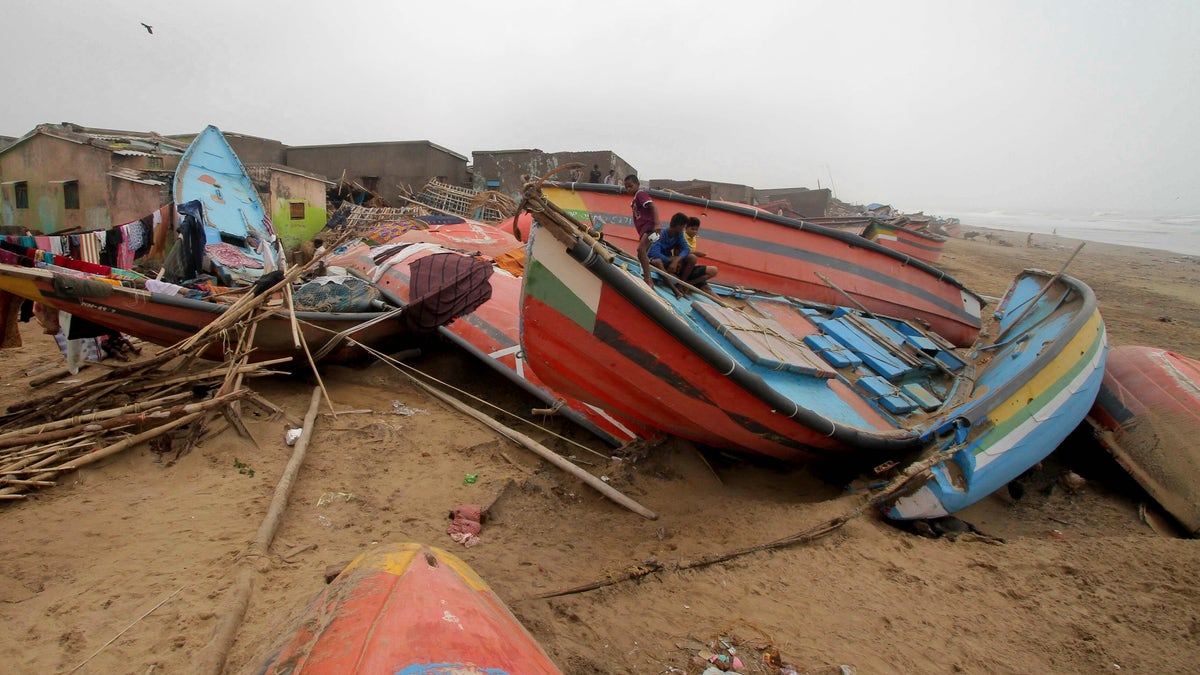 Children sit on a boat damaged by Cyclone Fani in the Penthakata fishing village of Puri, in the eastern Indian state of Orissa, Saturday, May 4, 2019. (AP Photo)