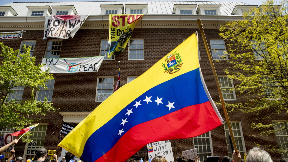 Pro-interim government opposition leader Juan Guaido, and pro-Nicolas Maduro supporters, separated by members of the uniformed Secret Service, rally outside of the Venezuelan Embassy in Washington, Tuesday, April 30, 2019. (AP Photo/Andrew Harnik)
