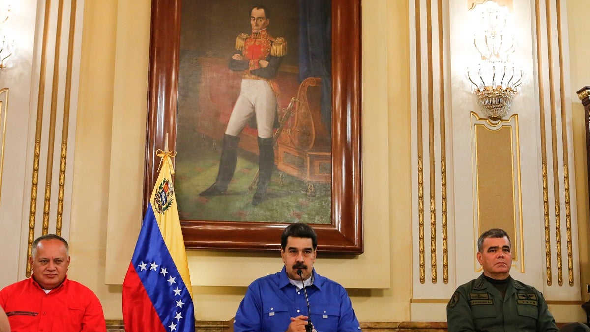 Venezuela's President Nicolas Maduro, center, flanked by Venezuela's Defense Minister Gen. Vladimir Padrino Lopez, right, and the President of the Constituent Assembly Diosdado Cabello, left, speaks during a televised national message at Miraflores Presidential Palace in Caracas, Venezuela on Tuesday.