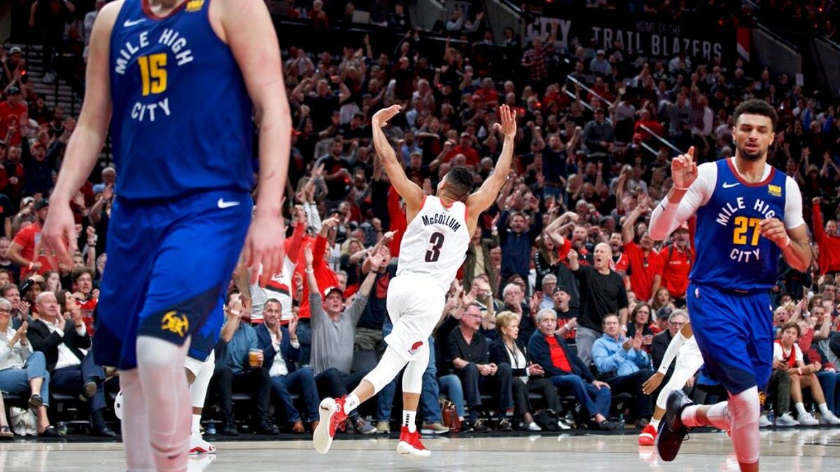 Portland Trail Blazers guard CJ McCollum, center, reacts after making a three point basket against the Denver Nuggets during overtime of Game 3 of an NBA basketball second-round playoff series Friday, May 3, 2019, in Portland, Ore.