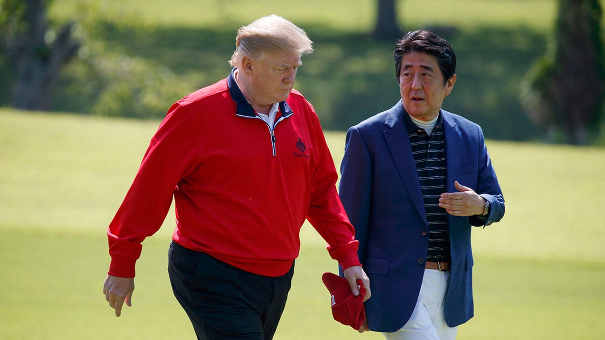 President Donald Trump walks with Japanese Prime Minister Shinzo Abe before playing a round of golf at Mobara Country Club, on Sunday, in Chiba, Japan. (Associated Press)
