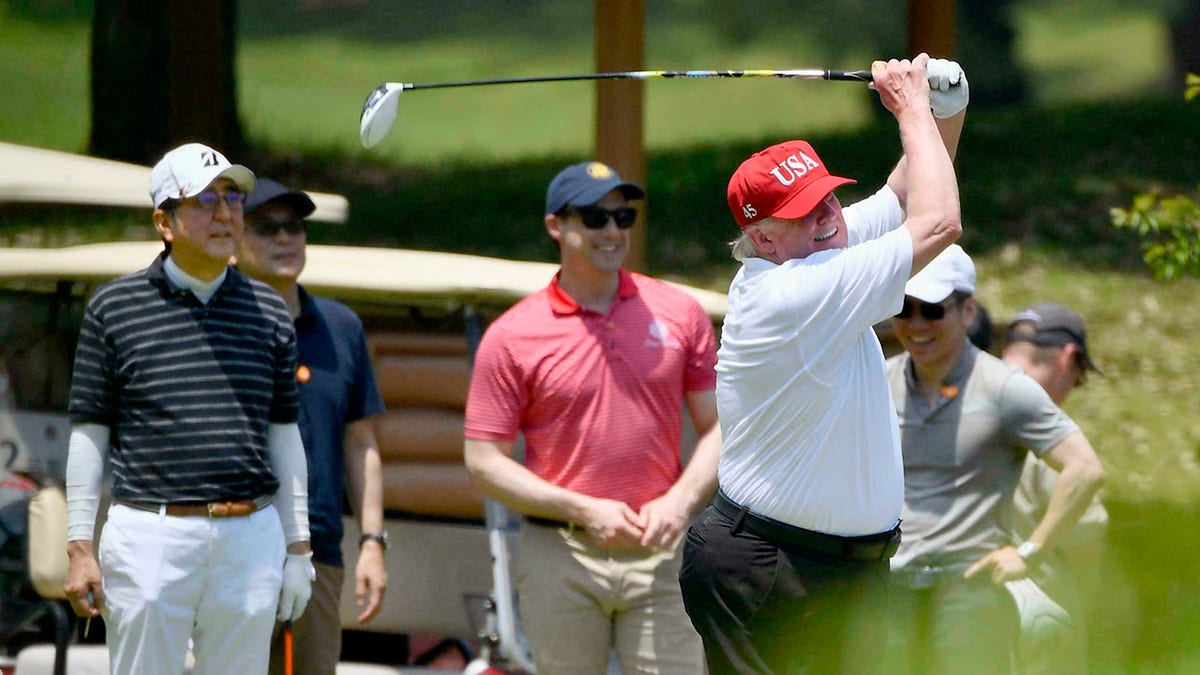 U.S. President Donald Trump, right, plays golf with Japanese Prime Minister Shinzo Abe, left, at Mobara Country Club in Mobara, south of Tokyo, on Sunday. (Associated Press)