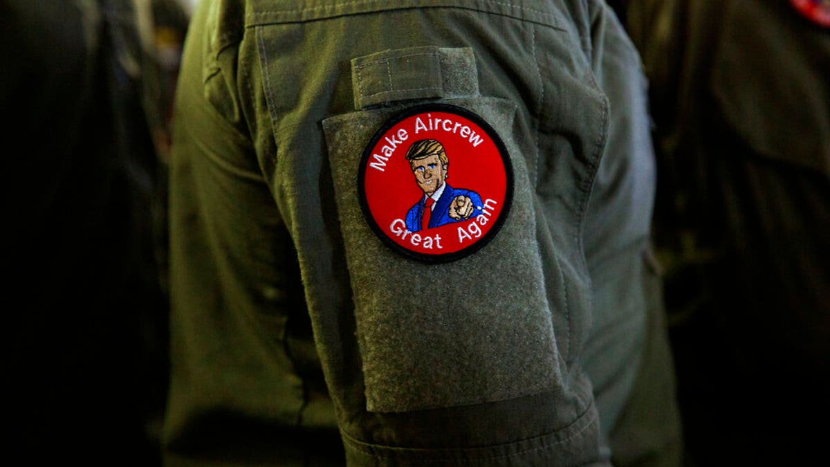 A service member wears a patch that says "Make Aircrew Great Again" as they listen to President Trump speak Tuesday aboard the USS Wasp in Japan. (Associated Press)