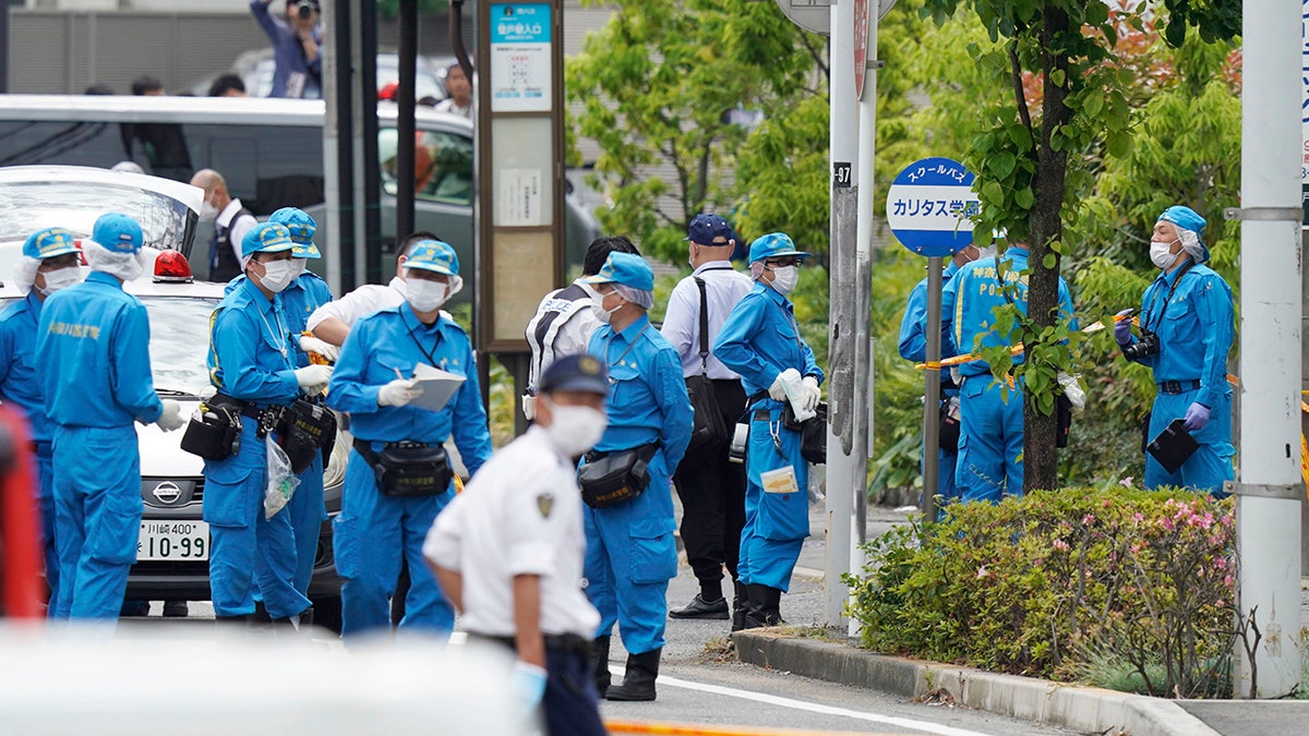 Investigators work near a bus stop for CARITAS Elementary School bus at the scene of an attack in Kawasaki, near Tokyo Tuesday, May 28, 2019. (Shigeyuki Inakuma/Kyodo News via AP)