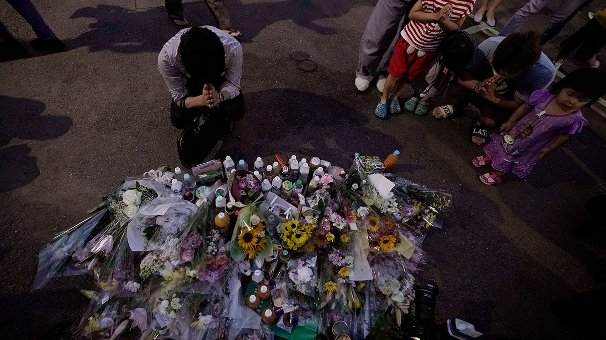 People pay their respects at a makeshift memorial for the victims of a knife attack Tuesday, May 28, 2019, in Kawasaki, just outside Tokyo. (AP Photo/Jae C. Hong)