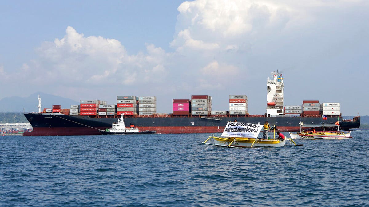 ​​​​​​​In this image released by Greenpeace, Greenpeace activists and other environmental organizations display a banner as the cargo ship MV Bavaria, the container vessel allegedly hired to ship back the 69 containers loaded with garbage from Canada, slowly enters the mouth of Subic Bay, Thursday, May 30, 2019 in Subic, Zambales province west of Manila, Philippines.