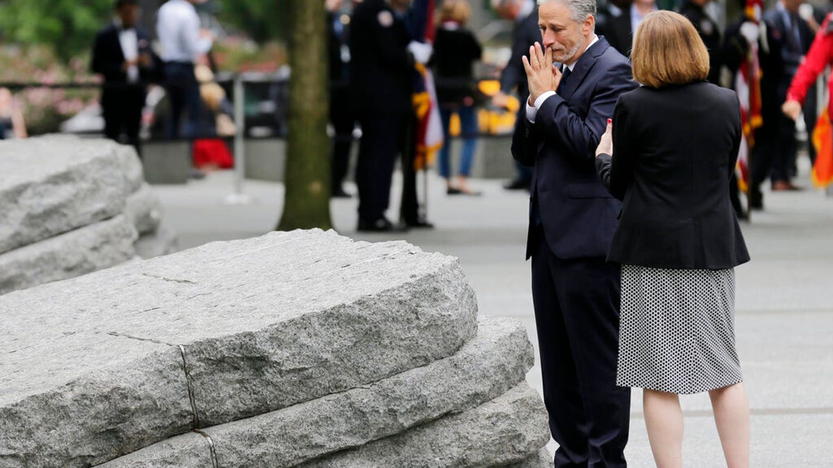 Comedian Jon Stewart talks with Alice Greenwald, CEO of the National September 11 Memorial & Museum, before the start of a dedication ceremony in New York on Thursday. Michael Bloomberg, former mayor, says the new memorial glade at the World Trade Center site "helps us fulfill our duty" to those who were sickened or died after responding to the Sept. 11 attacks. (AP Photo/Seth Wenig)