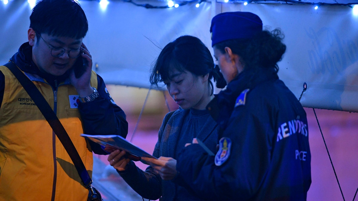 South Korean Embassy personnel help identifying the victims of an accident during a search operation for survivors on the River Danube in downtown Budapest, Hungary, Thursday, May 30, 2019. (Zsolt Szigetvary/MTI via AP)