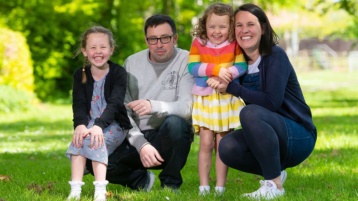 Rachel Avon, with her daughters Ffion (left) and Cari, and partner Ross, said she would have never known she had the rare cancer if her growing unborn baby wasn't pushing on the tumor to cause pain.