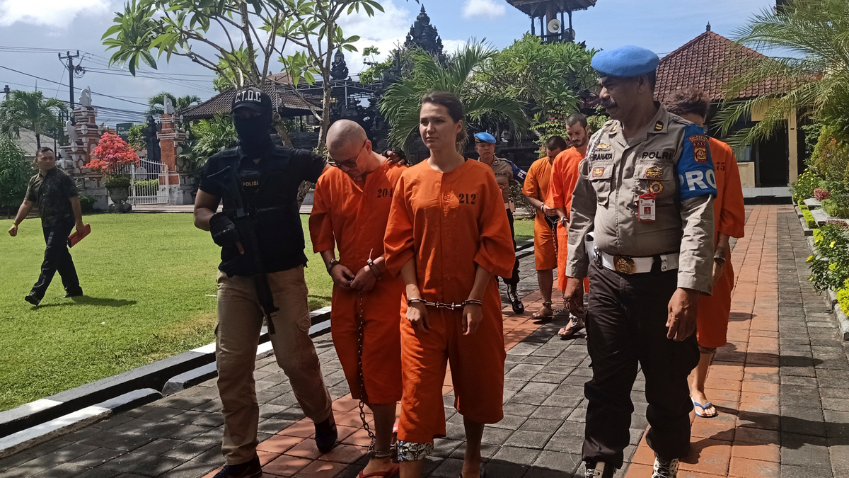 Police officers escort foreign nationals arrested for selling drugs prior to a press conference at the regional police headquarters in Denpasar, Bali, Indonesia, Friday, May 31, 2019. Police on the resort island have arrested an American, two Spaniards and two Russians for selling cocaine on the island.