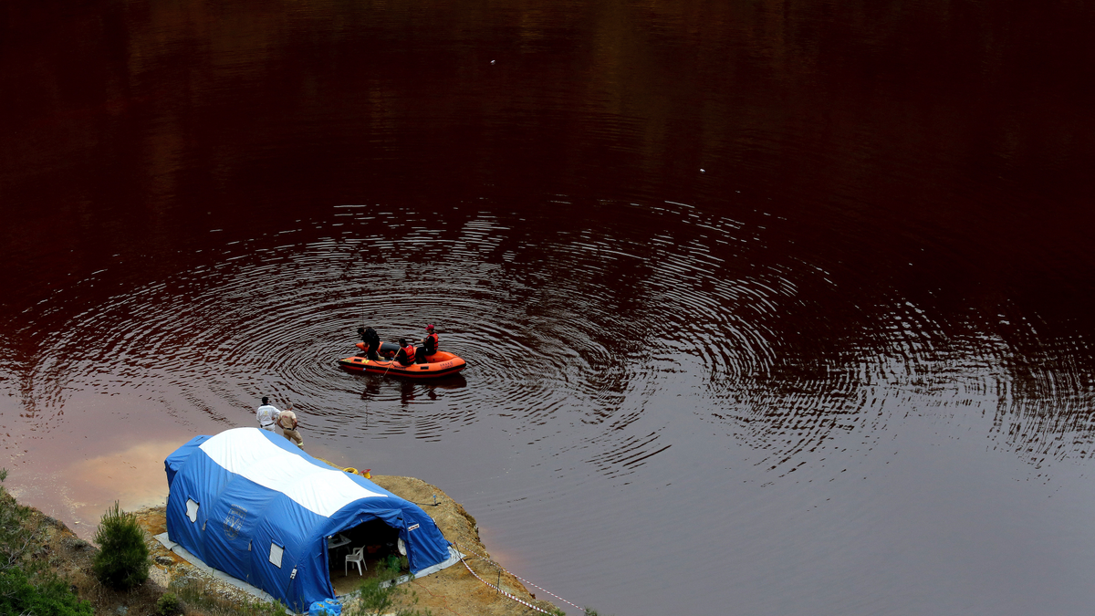 Members of the Cyprus Special Disaster Response Unit search for suitcases in a man-made lake, near the village of Mitsero outside of the capital Nicosia, Cyprus, Wednesday, May 1, 2019.