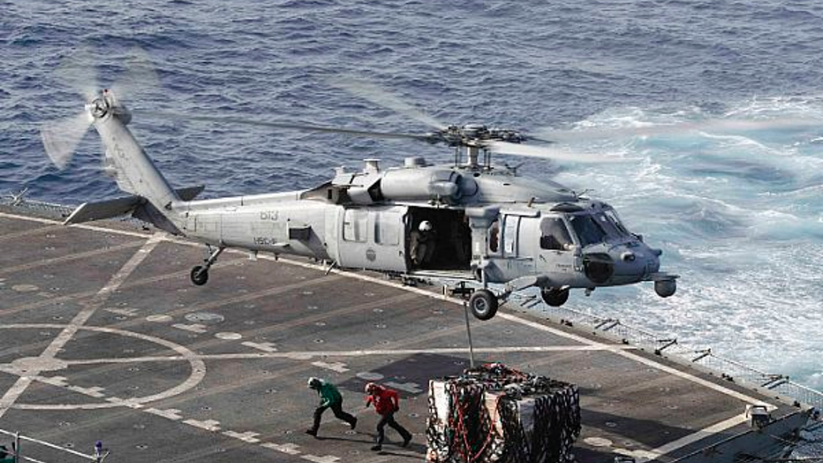 ARQUIVO - Nesta foto de 19 de maio de 2019, um helicóptero MH-60S Sea Hawk transporta carga do navio de apoio de combate rápido USNS Arctic para o porta-aviões da classe Nimitz USS Abraham Lincoln durante uma operação de reabastecimento no mar no Mar da Arábia.