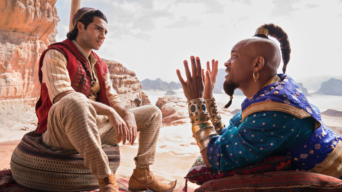 This image released by Disney shows Mena Massoud as Aladdin, left, and Will Smith as Genie in Disney's live-action adaptation of the 1992 animated classic 
