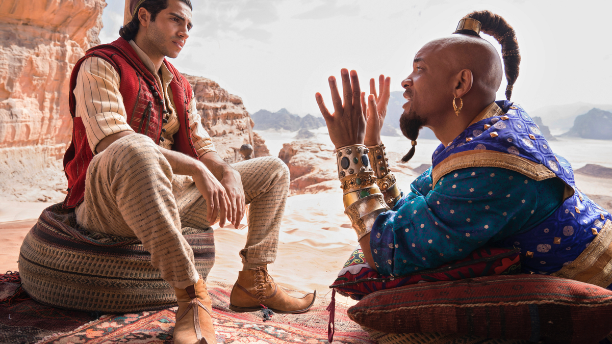 This image released by Disney shows Mena Massoud as Aladdin, left, and Will Smith as Genie in Disney's live-action adaptation of the 1992 animated classic 