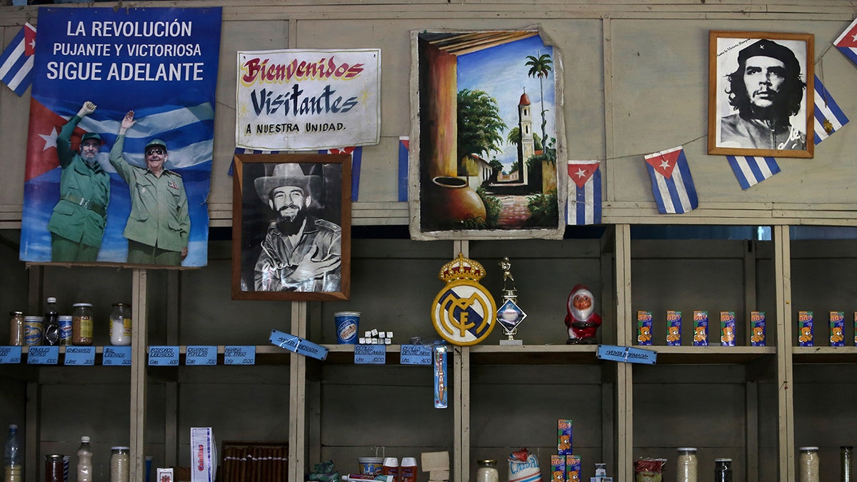 A poster showing late Cuban President Fidel Castro and his brother Raul, former president and now leader of the Communist Party, and the headline reading "The thriving and victorious revolution goes on" hangs inside a subsidized state store, or "bodega", where Cubans can buy basic products with a ration book they receive annually from the government, in Havana, Cuba April 10, 2019. The other photographs show late rebel heroes Camilo Cienfuegos (C) and Ernesto "Che" Guevara. REUTERS/Fernando Medina