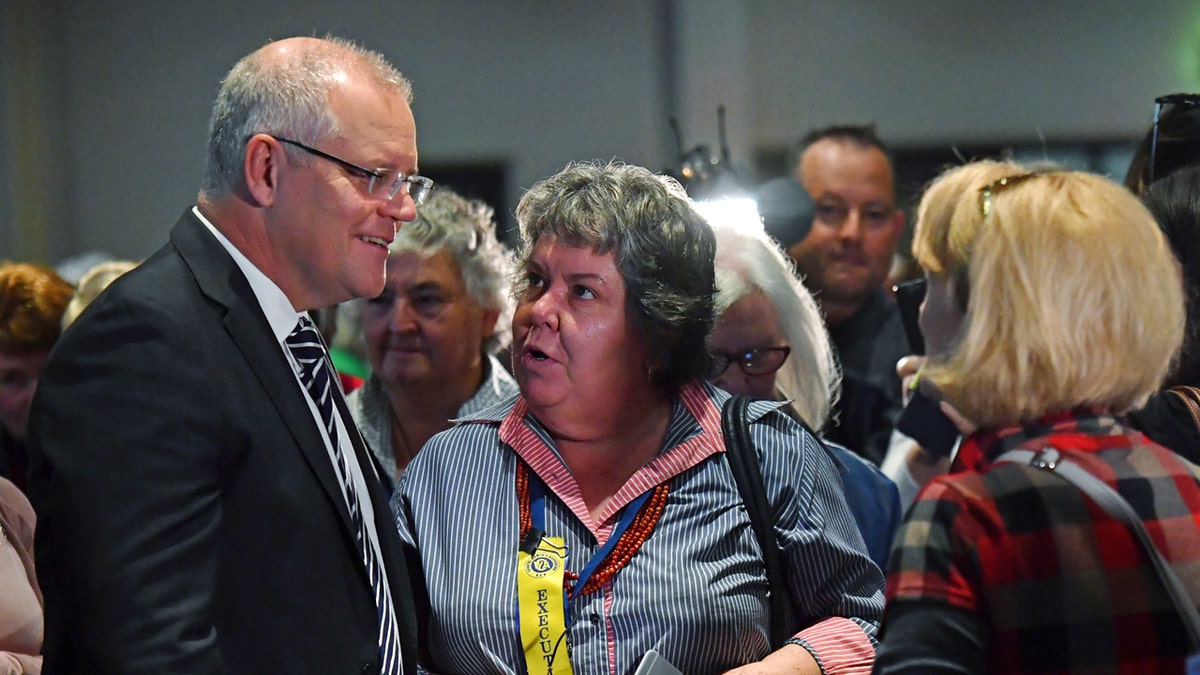 Australian Prime Minister Scott Morrison, left, talks with attendees at the Country Women's Association NSW annual conference after he was hit on the head with an egg during a protest at the event.