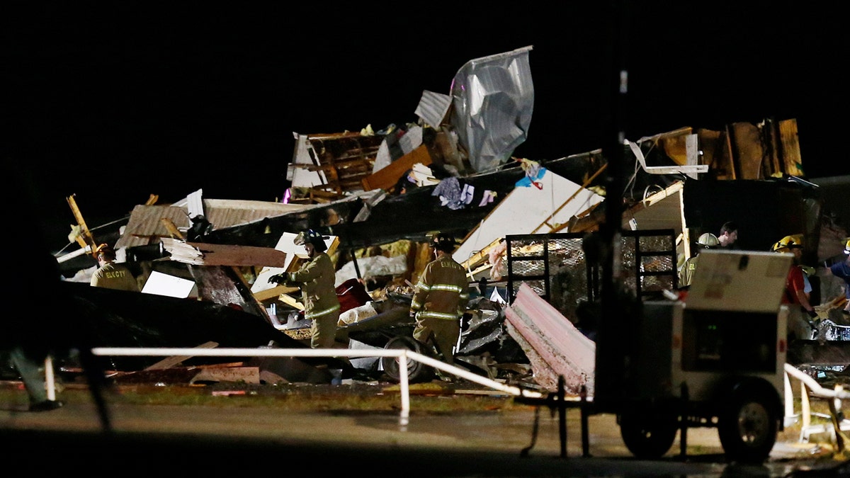 Emergency workers search through debris from a mobile home park, Sunday, May 26, 2019, in El Reno, Ok., following a tornado touchdown late Saturday night.