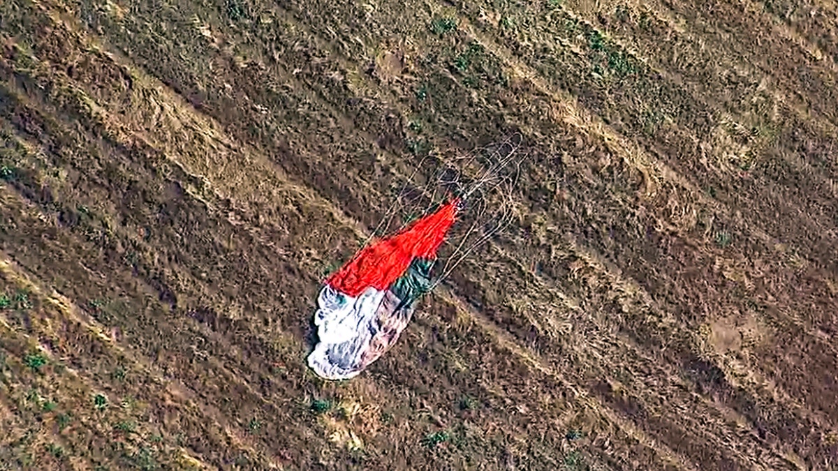 This photo taken from video provided by KABC-TV shows the parachute left by the pilot who ejected before his F-16 fighter jet crashed into a warehouse just outside March Air Reserve Base in Riverside, Calif., Thursday afternoon. (Associated Press)