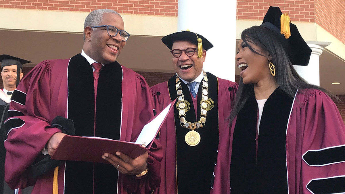 Robert F. Smith, left, laughs with David Thomas, center, and actress Angela Bassett at Morehouse College on Sunday, May 19, 2019, in Atlanta. Smith, a billionaire technology investor and philanthropist, said he will provide grants to wipe out the student debt of the entire graduating class at Morehouse College - an estimated $40 million.