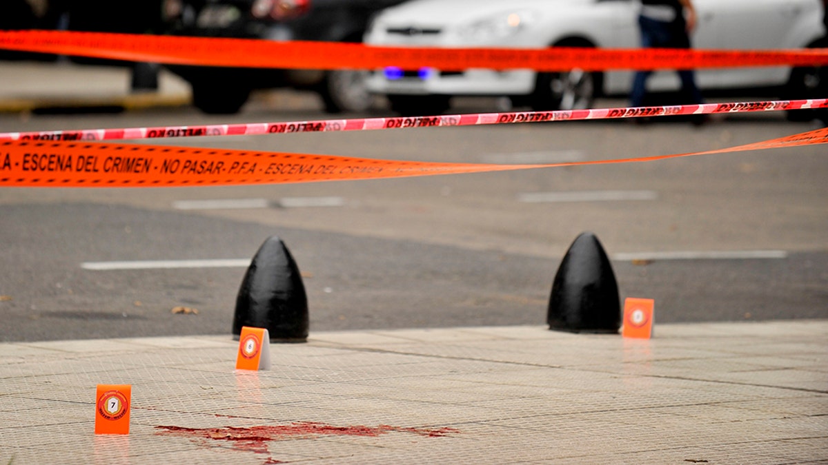 Evidence tent markers dot the crime scene where lawmaker Hector Olivares was seriously injured and another man was killed after they were shot at from a parked car near Congress in Buenos Aires, Argentina, Thursday, May 9, 2019. (AP Photo/Natacha Pisarenko)