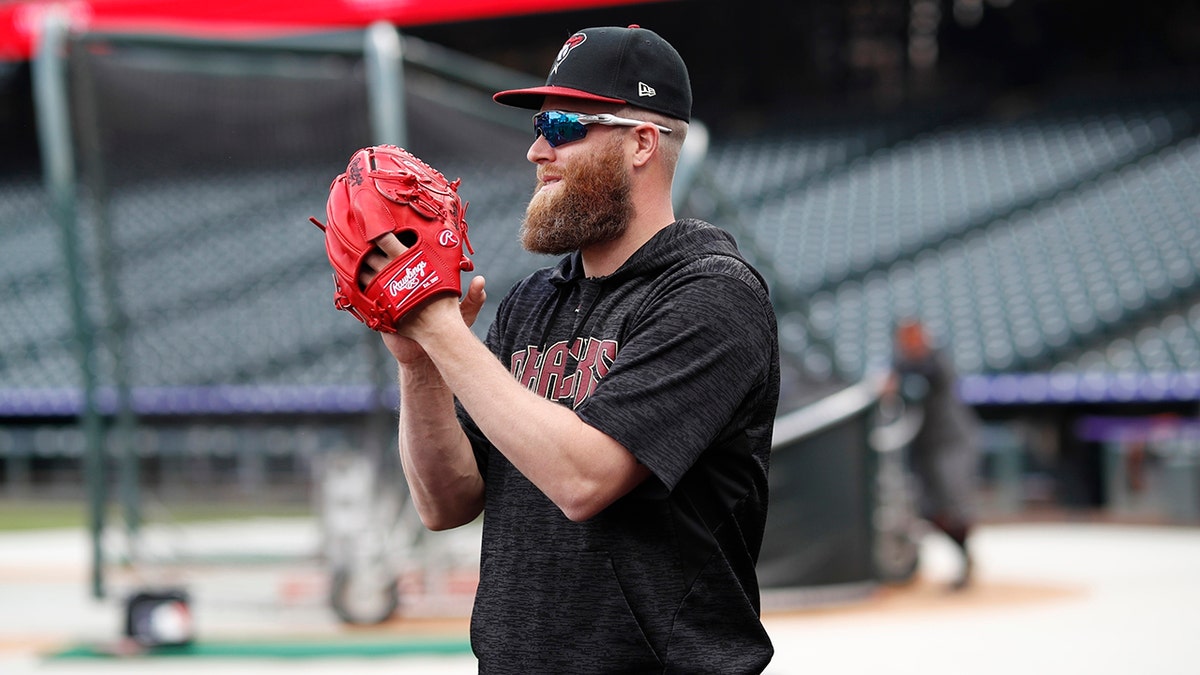 Arizona Diamondbacks relief pitcher Archie Bradley applauds for teammates as they warm up before facing the Colorado Rockies in a baseball game Saturday, May 4, 2019, in Denver. (AP Photo/David Zalubowski)