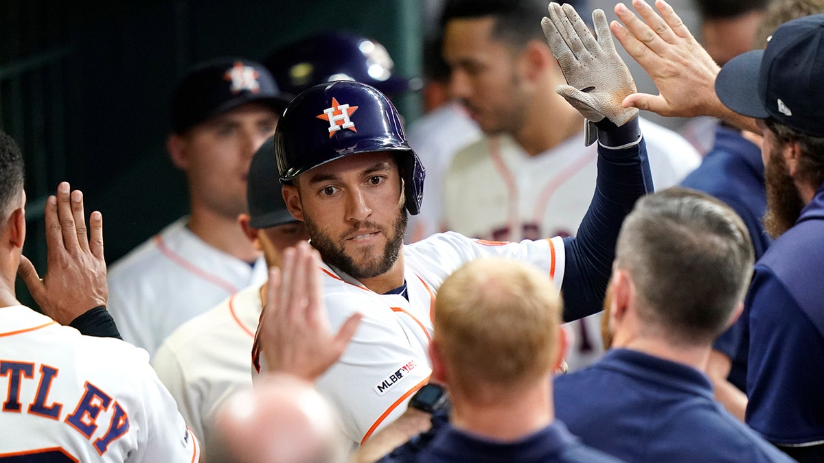 Houston Astros' George Springer is congratulated in the dugout after hitting a home run against the Cleveland Indians during the third inning of a baseball game Thursday, April 25, 2019, in Houston. (AP Photo/David J. Phillip)