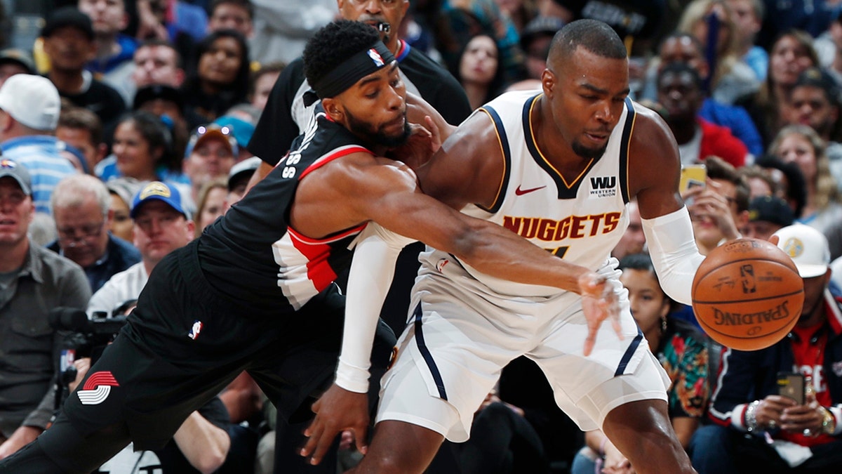 Portland Trail Blazers forward Maurice Harkless, left, tries to steal the ball from Denver Nuggets forward Paul Millsap during the second half of Game 5 of an NBA basketball second-round playoff series Tuesday, May 7, 2019, in Denver. The Nuggets won 124-98. (AP Photo/David Zalubowski)