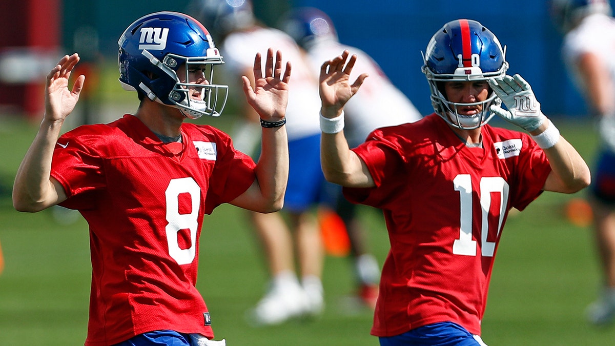 New York Giants quarterbacks Eli Manning (10) and Daniel Jones (8) warm up during an NFL football practice Monday, May 20, 2019, in East Rutherford, N.J. (AP Photo/Adam Hunger)