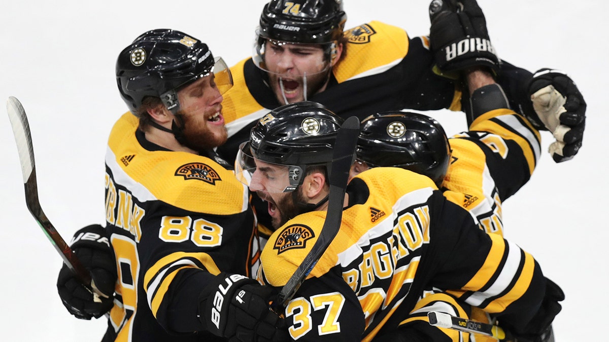 Boston Bruins' Patrice Bergeron (37) is congratulated by teammates after his goal against the Carolina Hurricanes during the third period in Game 1 of the NHL hockey Stanley Cup Eastern Conference finals, Thursday, May 9, 2019, in Boston. (AP Photo/Charles Krupa)
