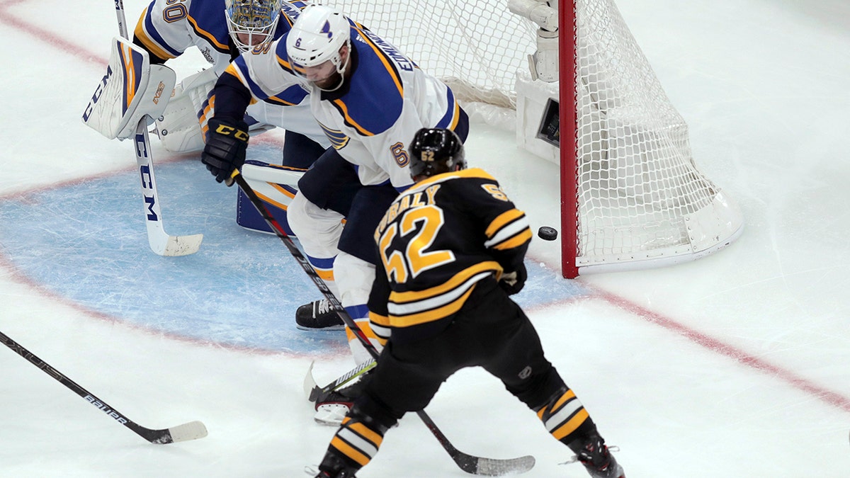 Boston Bruins' Sean Kuraly (52) scores a goal past St. Louis Blues goaltender Jordan Binnington (50) and Joel Edmundson (6) during the third period in Game 1 of the NHL hockey Stanley Cup Final, Monday, May 27, 2019, in Boston. (AP Photo/Charles Krupa)